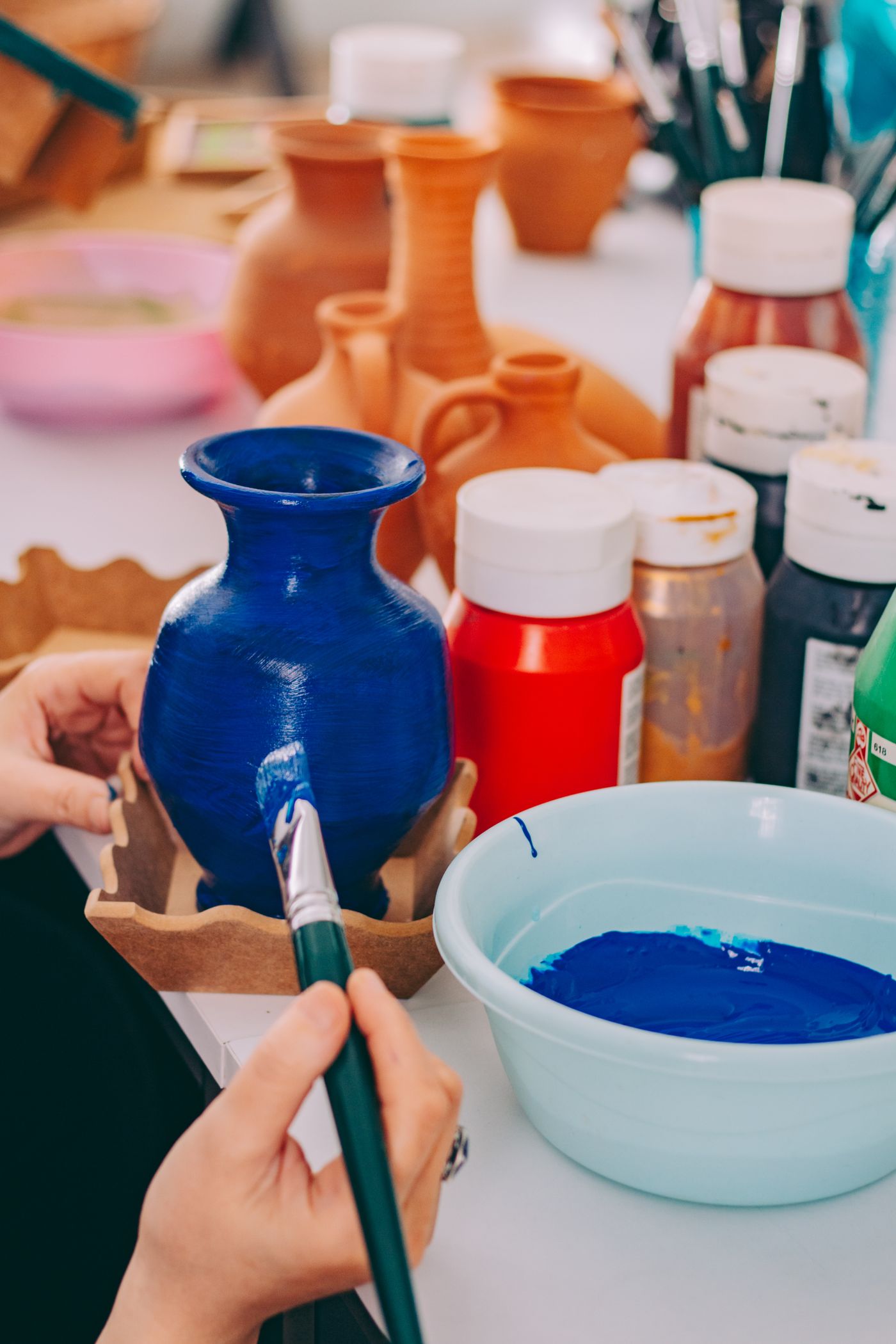 An artisan hand-painting a ceramic vase