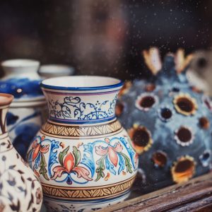 Intricately painted artisan ceramic vases displayed in a shop window.