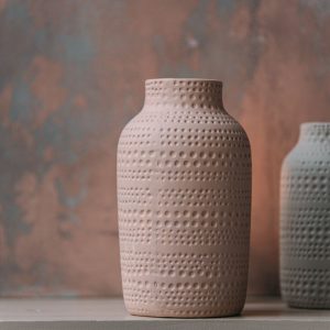 Two handcrafted textured ceramic vases on a clean white surface.
